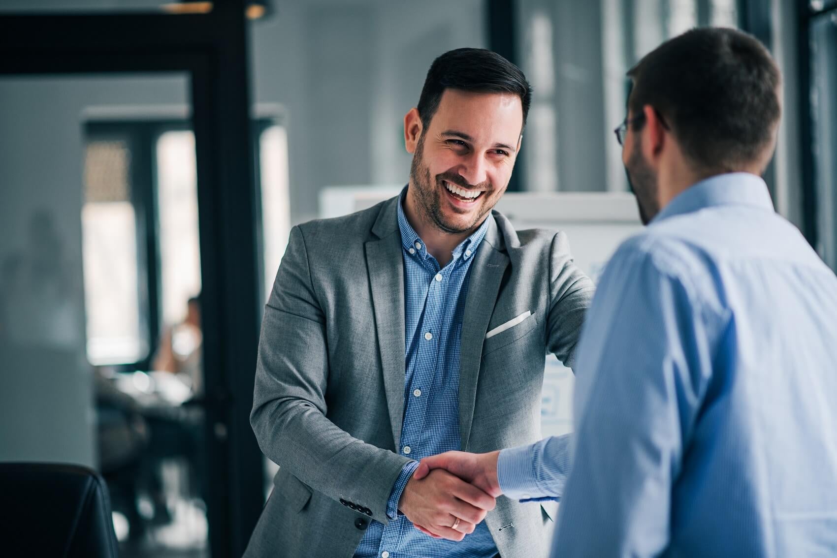 finance professional smiling and shaking hands with chevy customer